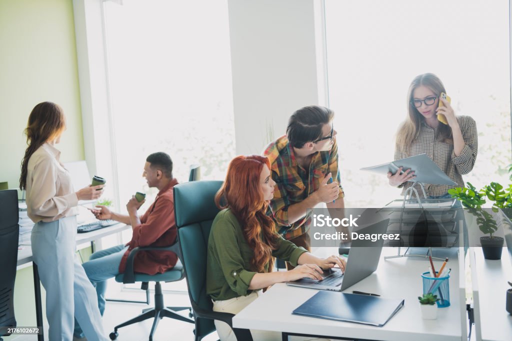 Photo of group five young corporate workers talk networking desktop workstation office business center indoors.